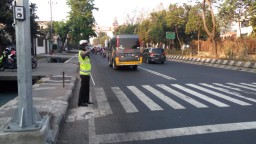 Polwan Satlantas Polres Tanjung Perak Bantu Menyeberangkan Anak Sekolah
